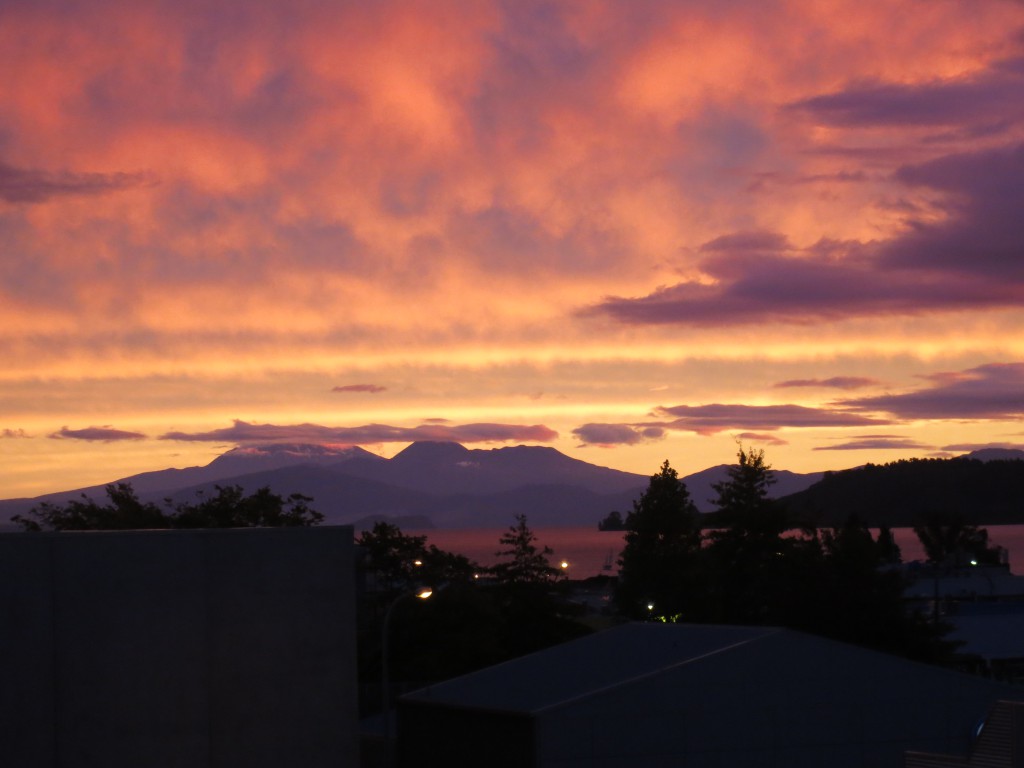 Abendliche Sicht auf die Berge des Tongariro-Nationalparks hinter dem rot schimmernden Lake Taupo