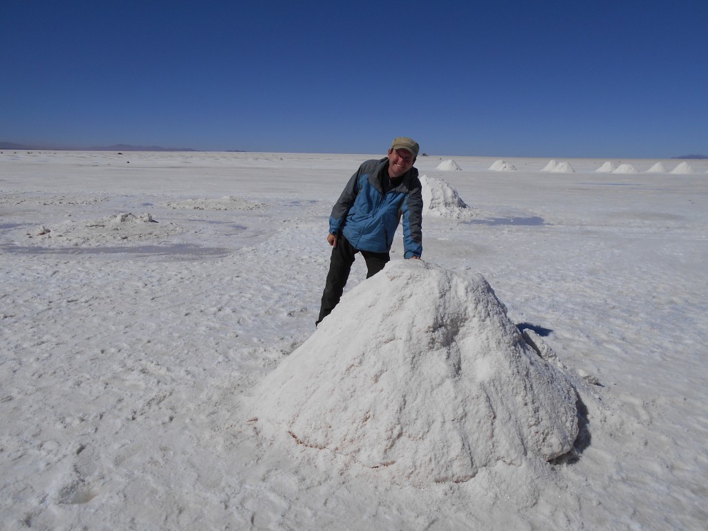 Vor einem Salzhäufchen bei der Salzgewinnung am Rande der Salar de Uyuni